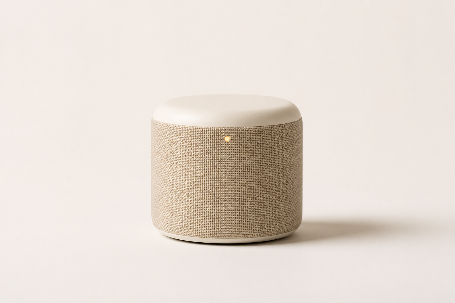 A small cylindrical speaker wrapped in sand-coloured acoustic fabric